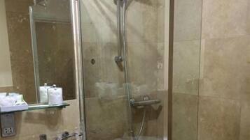 Ein Badezimmer mit Duschkabine, Waschbecken und Spiegel.