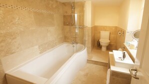 Un baño con bañera, inodoro y lavabo.