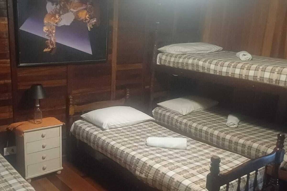 Una habitación con literas, una mesita de noche, una lámpara y un televisor.