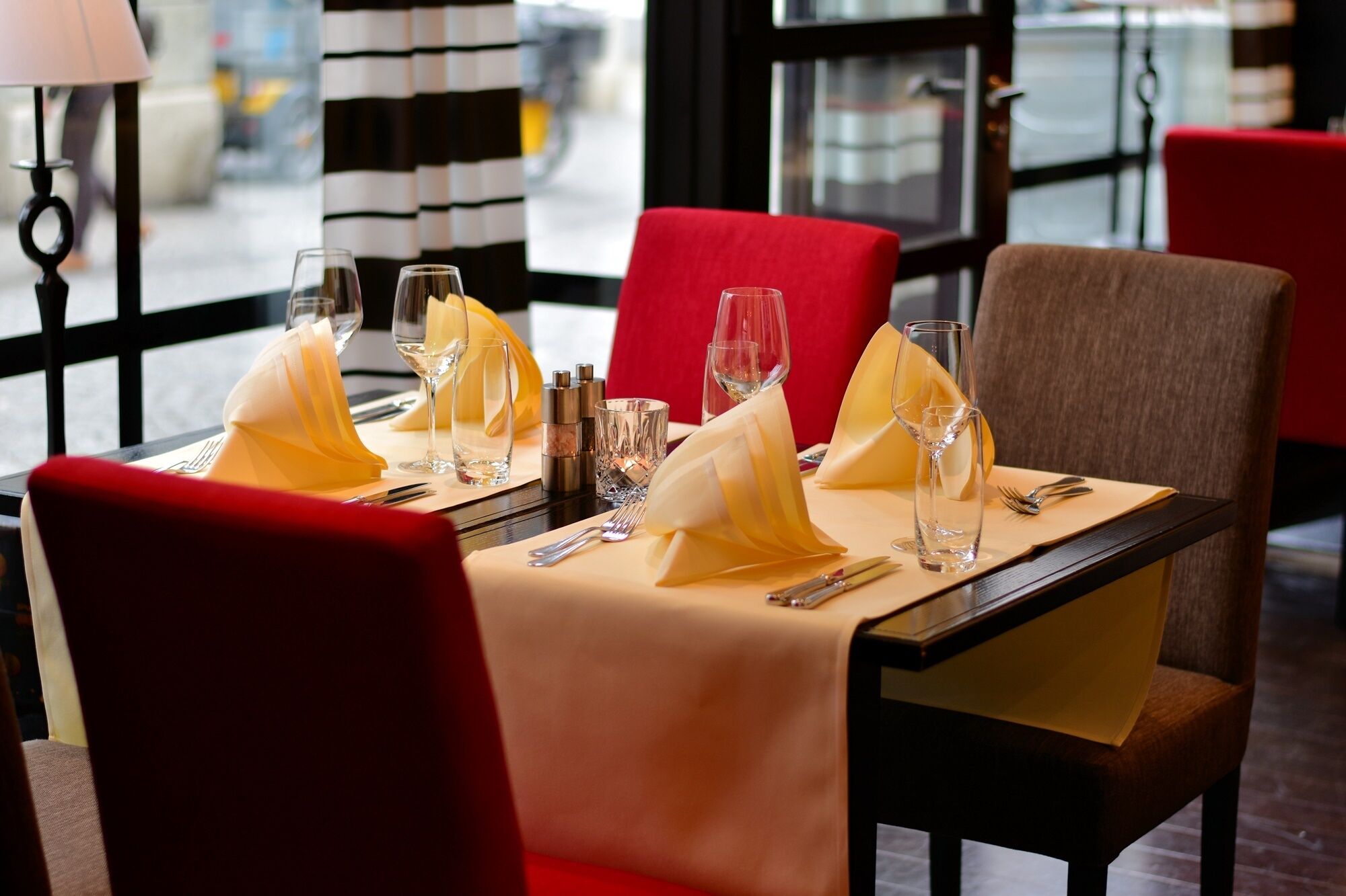 A dining table set with multiple wine glasses, a salt and pepper shaker, and a folded napkin.