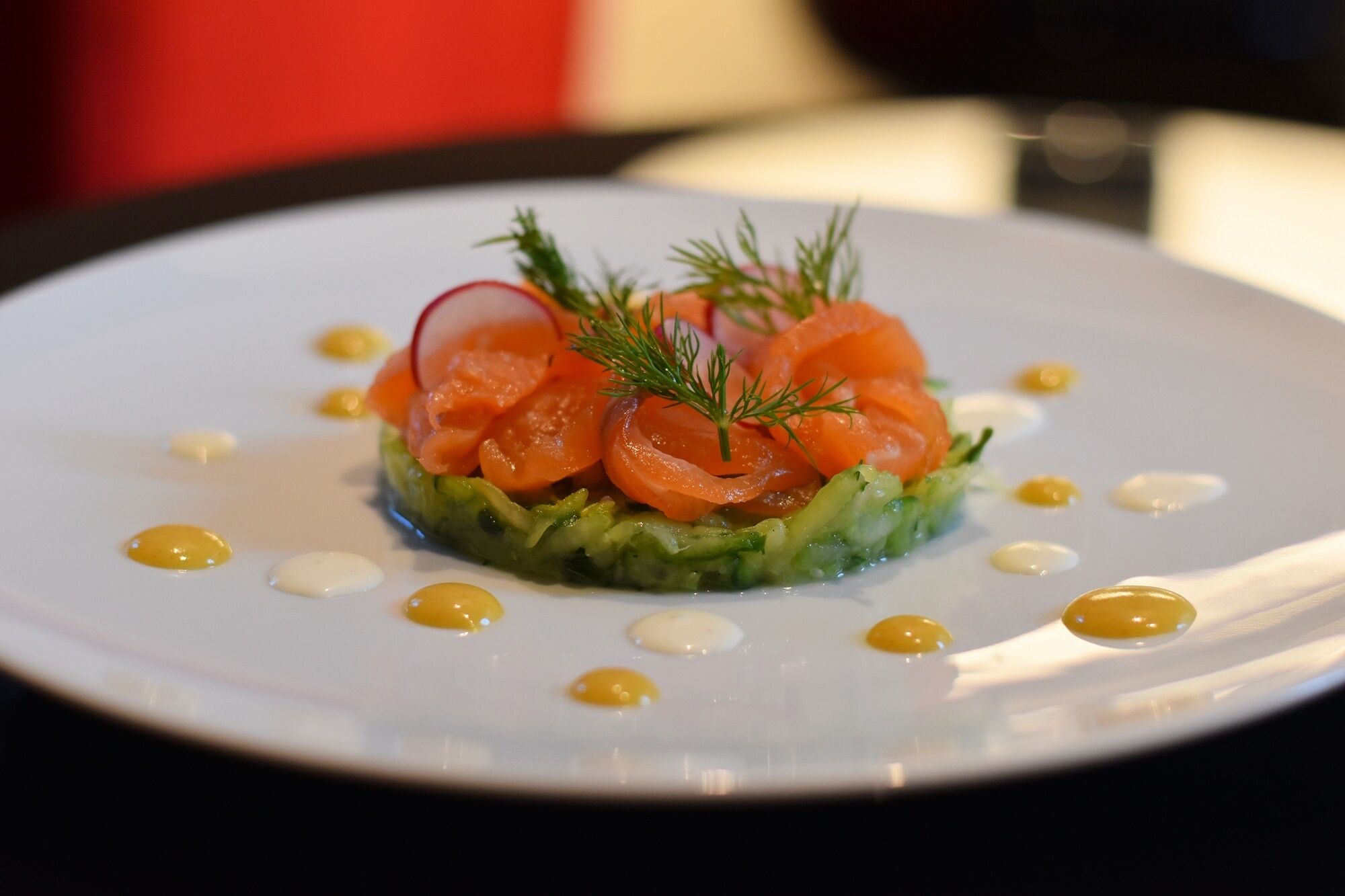 Plato con salmón, aguacate y una guarnición.