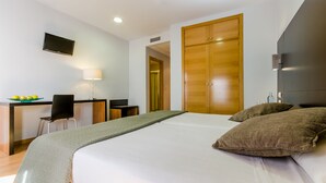 A hotel room with a bed, a desk with a chair, a TV, and a wardrobe. - Hotel YIT Alcover (Granada)