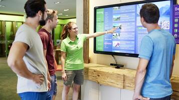 A group of people interacting with a digital display in a modern setting.