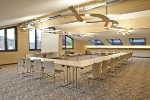 A conference room with a long table, multiple chairs, and a whiteboard. - Explorer Hotel Montafon (Gaschurn)