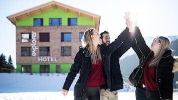 En bygning med et skilt, der viser ordet "HOTEL", foran et sneklædt landskab.