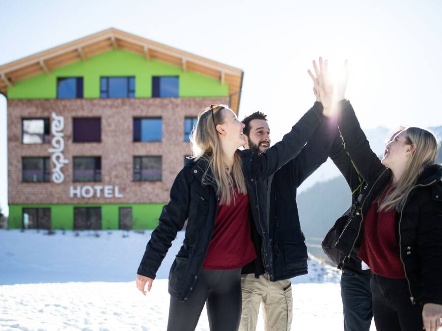 En bygning med et skilt, der viser ordet "HOTEL", foran et sneklædt landskab.