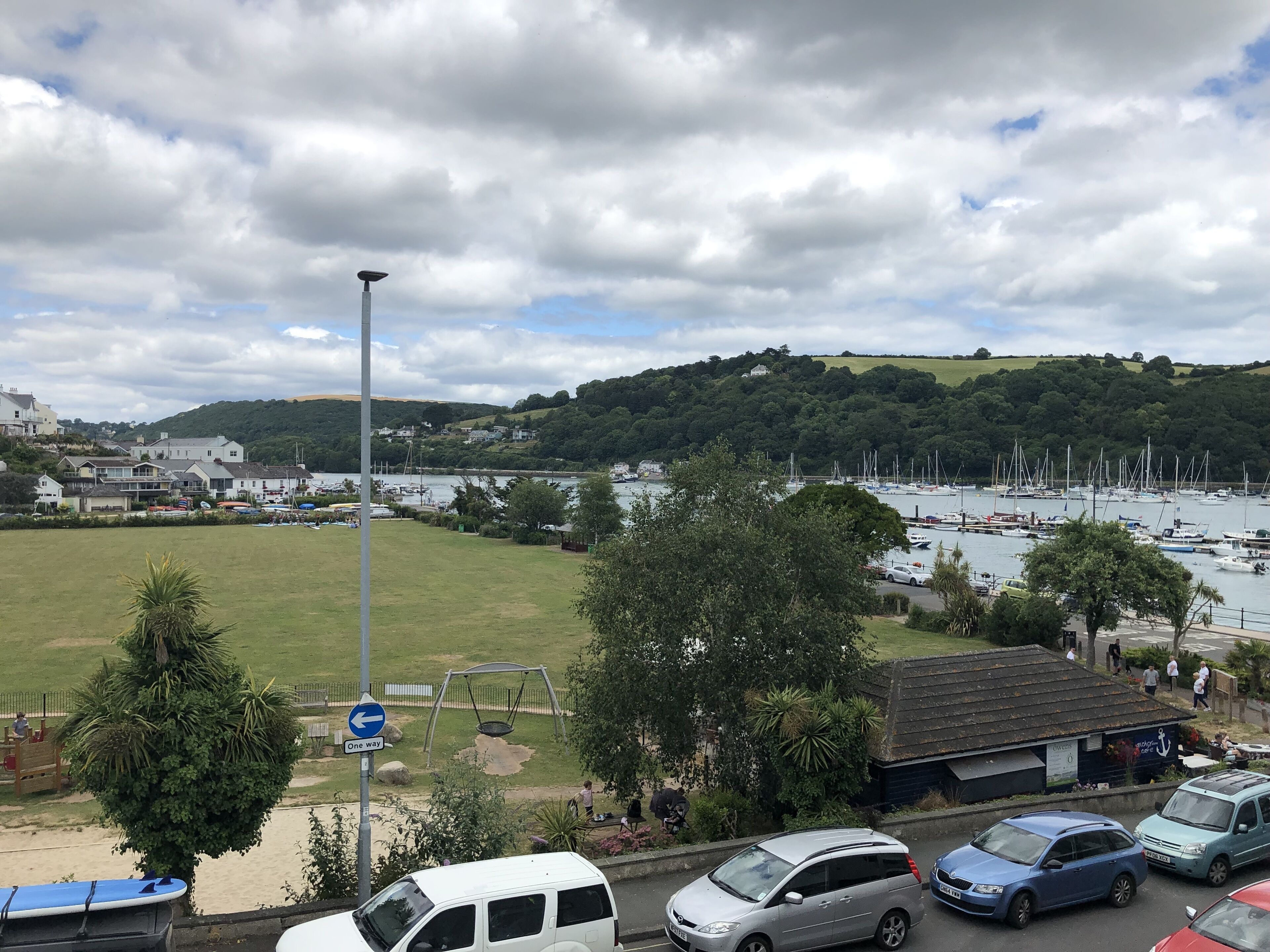 A coastal view with a marina, grassy areas, and a swing set.