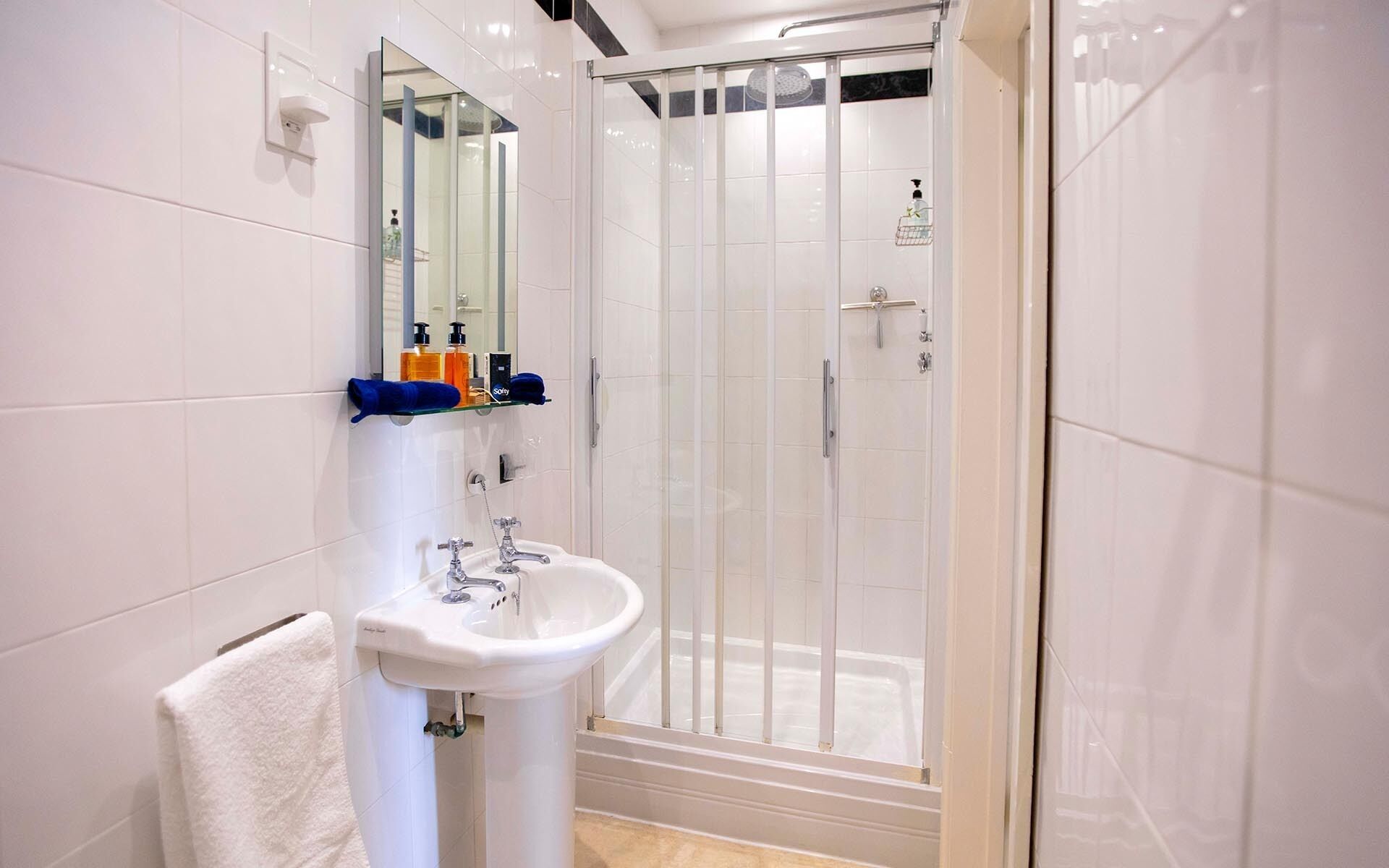 Ein modernes Badezimmer mit Waschbecken, Spiegel und einer Duschkabine.