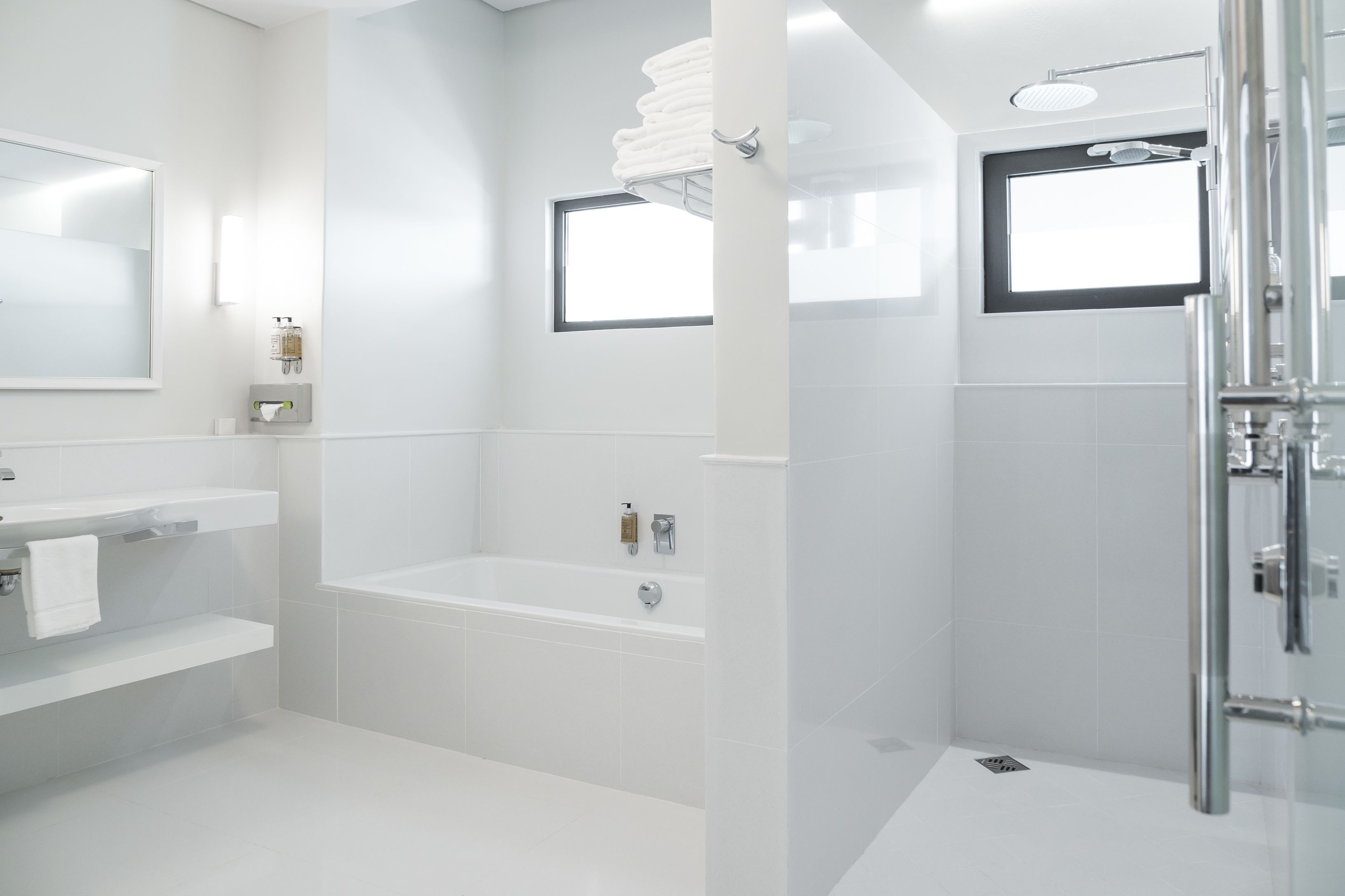 Een moderne badkamer met een bad, een douche en een toilet.