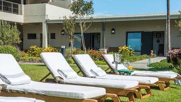 Alberca al aire libre, sombrillas en la alberca y camastros