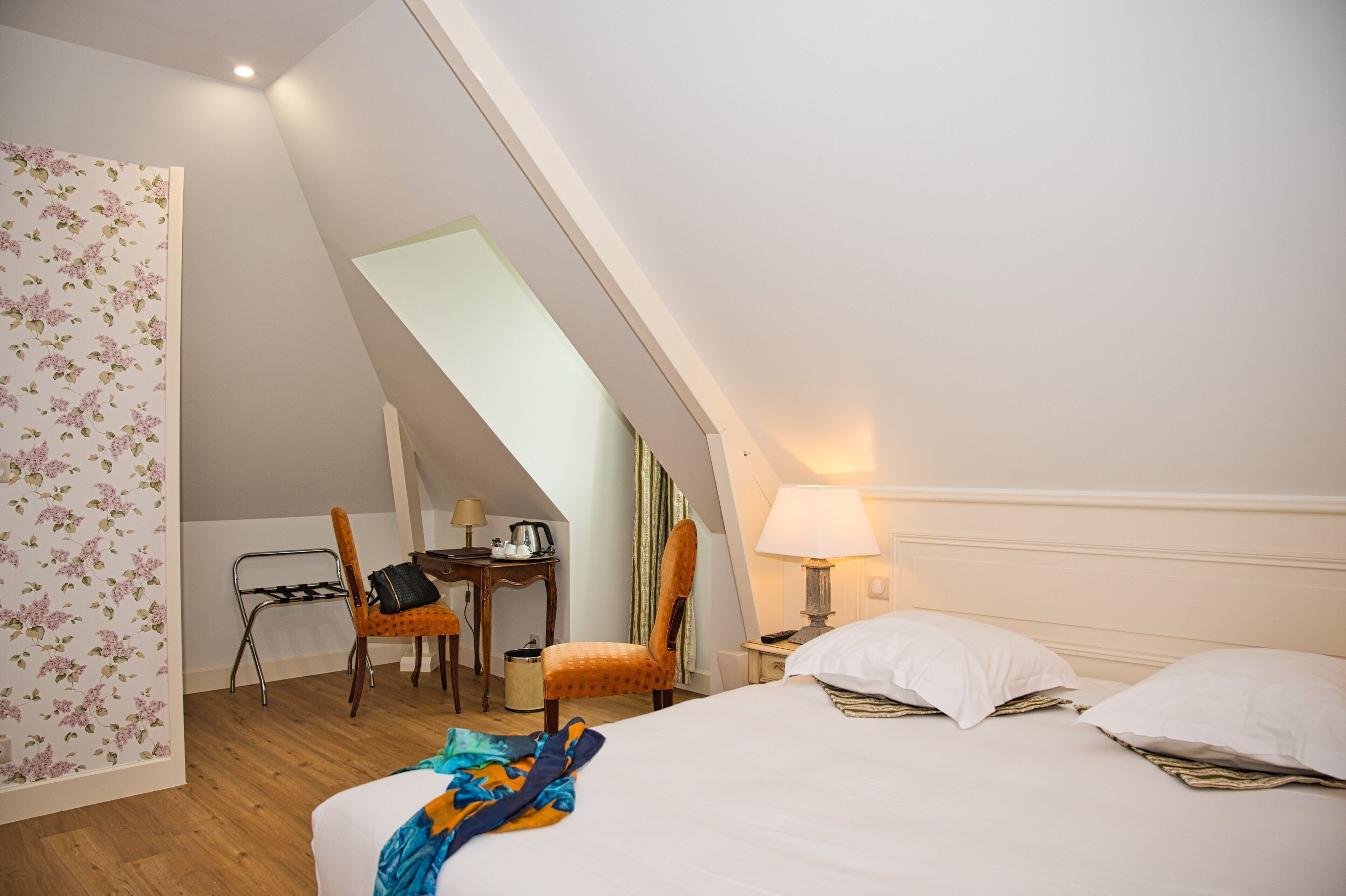 Habitación de hotel con cama, escritorio y silla.