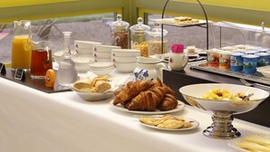 Un bufé de desayuno con diversas opciones de comida y bebidas.