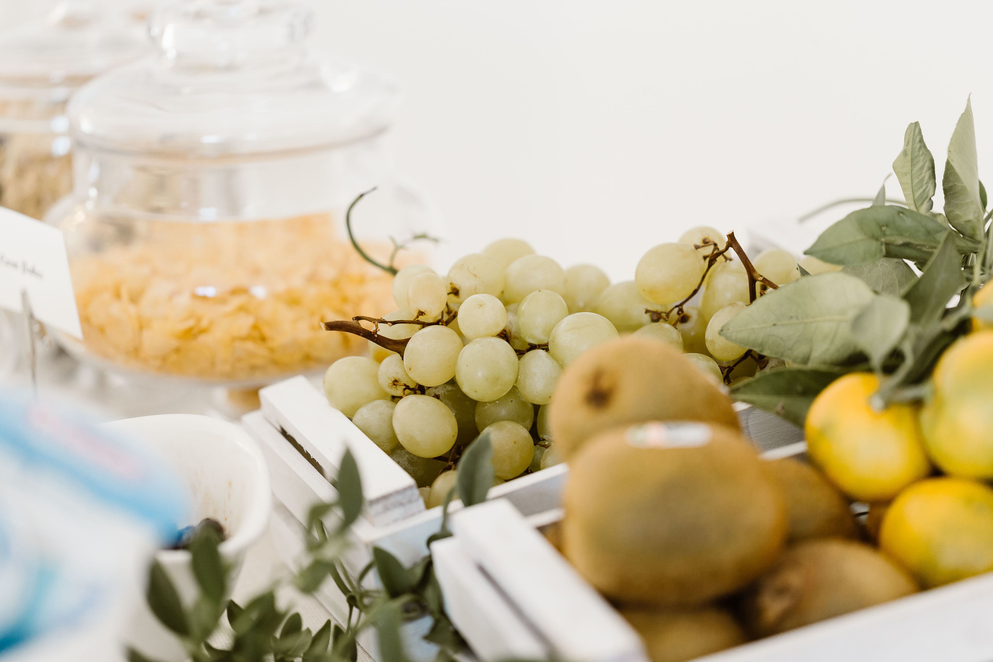 A variety of fruits including grapes, kiwis, and lemons on a table.