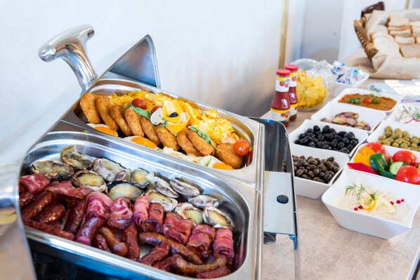 Un bufé con diversas opciones de comida, incluyendo carnes, mariscos y vegetales.