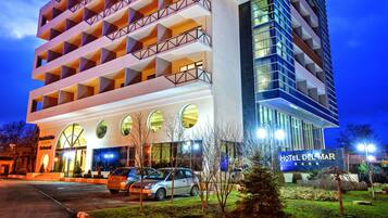 Hotel Delmar features a modern architectural design with a glass and solid facade.