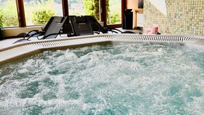 A hot tub with a wooden ceiling and large windows. - Vital Hotel Krainz mit Nebenhaus Familien Hotel (Jennersdorf)