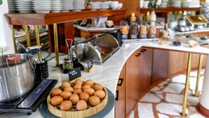 A buffet setup with a variety of dishes, a large pot, and a bowl of eggs. - Vital Hotel Krainz mit Nebenhaus Familien Hotel (Jennersdorf)
