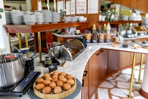 A buffet setup with a variety of dishes, a large pot, and a bowl of eggs. - Vital Hotel Krainz mit Nebenhaus Familien Hotel (Jennersdorf)