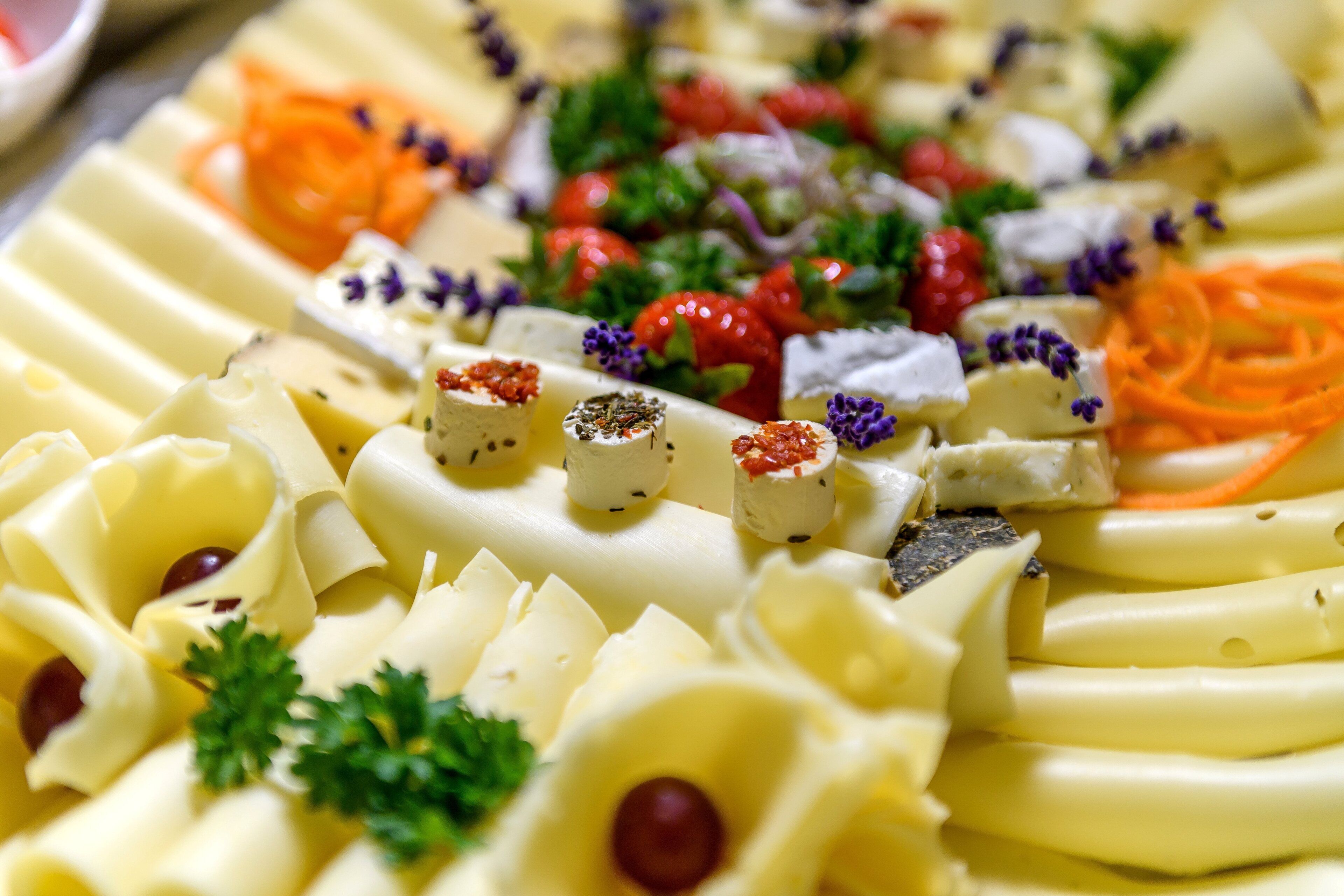 A neatly arranged platter with various food items, garnished with herbs and berries.
