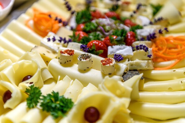 A neatly arranged platter with various food items, garnished with herbs and berries. - Vital Hotel Krainz mit Nebenhaus Familien Hotel (Jennersdorf)