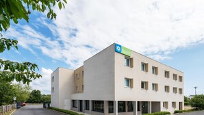 Ein modernes Hotelgebäude mit einem Schild, das es als 'Suite Hotel' kennzeichnet.