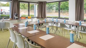 A conference room with tables, chairs, and water bottles.