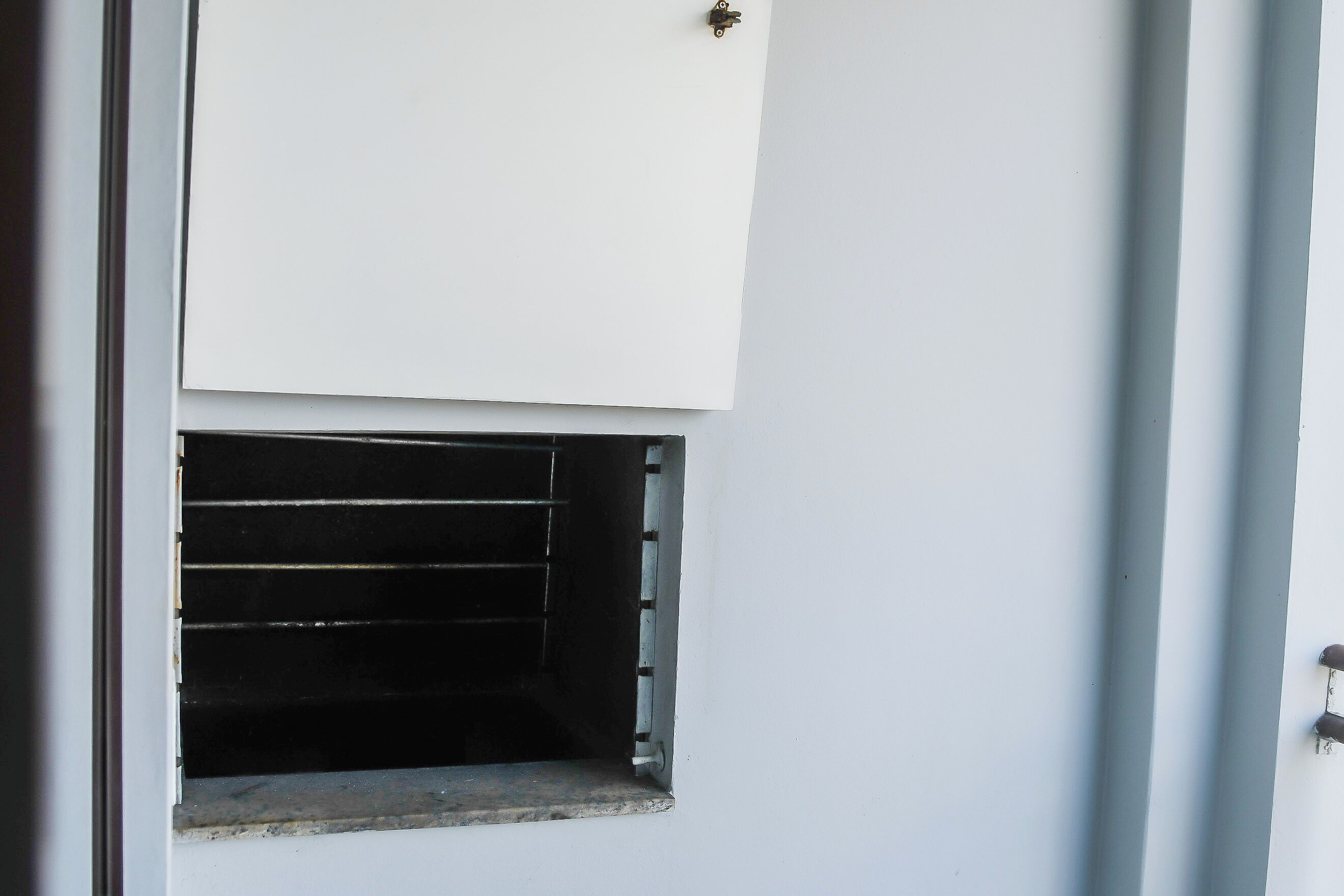 A white door with a small window and a metal handle.