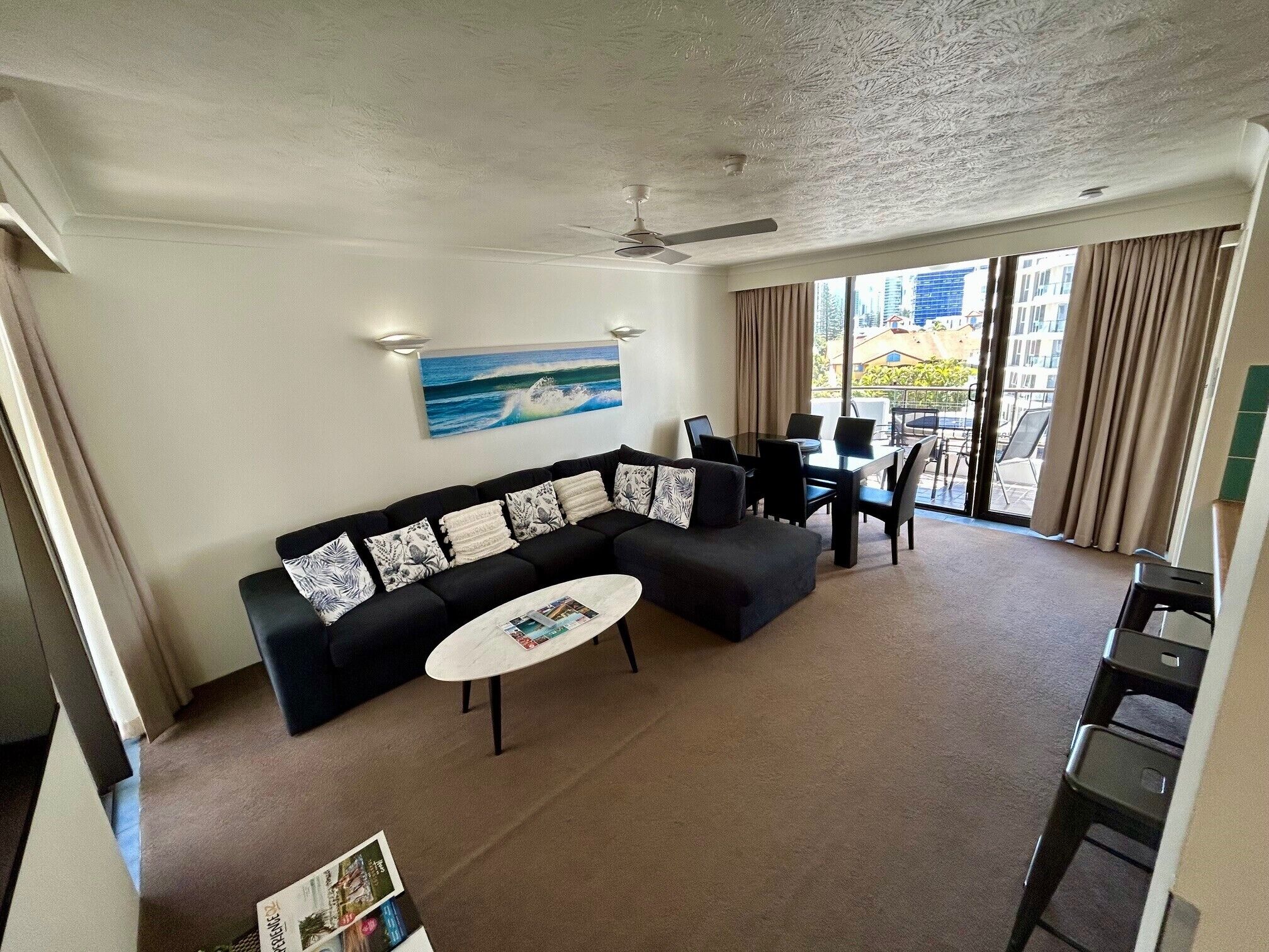 A living room with a sofa, coffee table, and dining area with chairs.