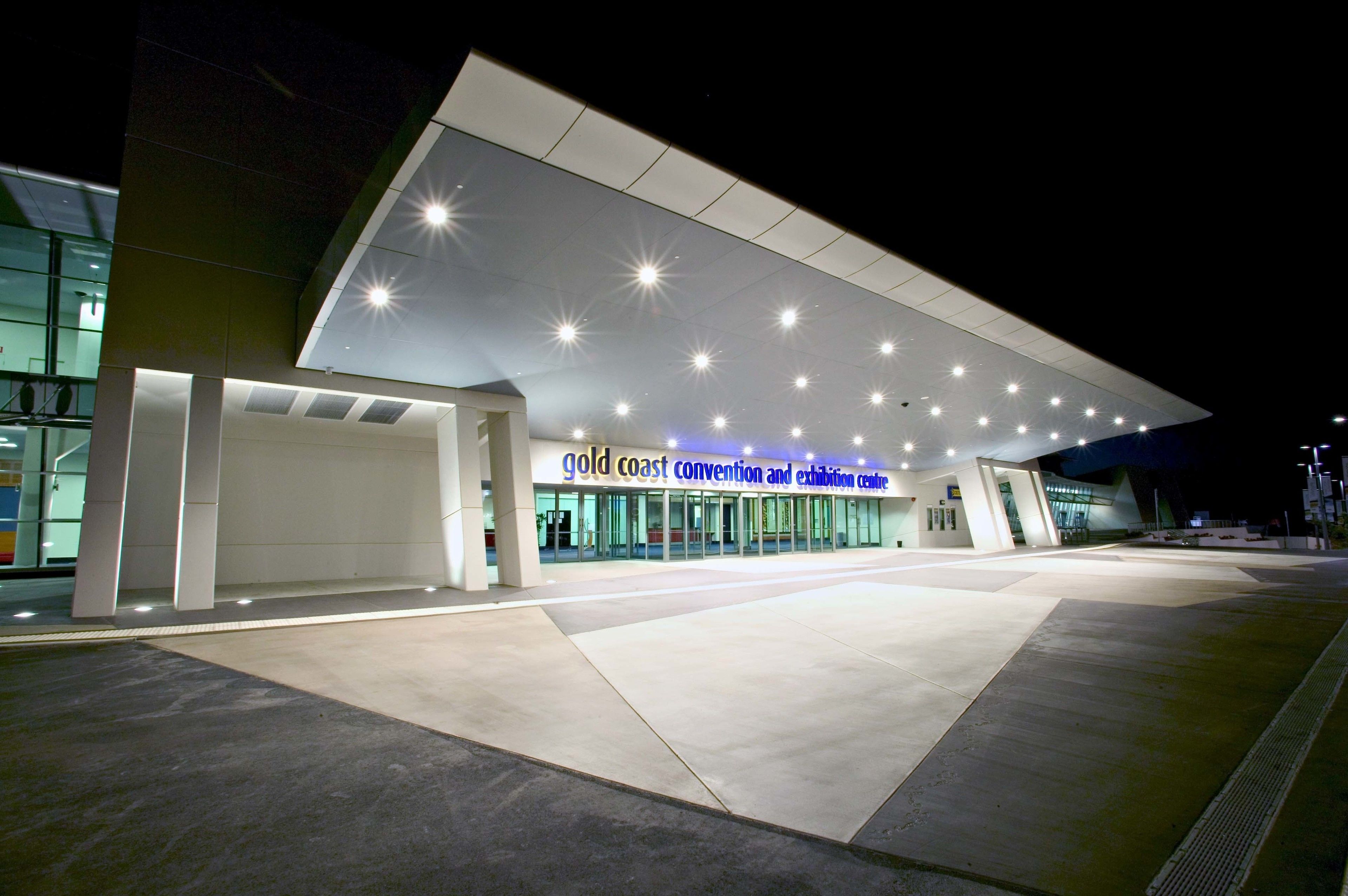 Ein modernes Kongresszentrum mit großzügigem Eingang und einem Schild, auf dem 