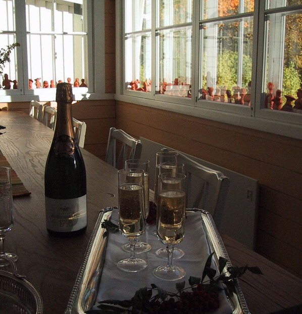A dining table with a bottle of champagne and three glasses on a tray. - Sikfors Herrgård (Hallefors)