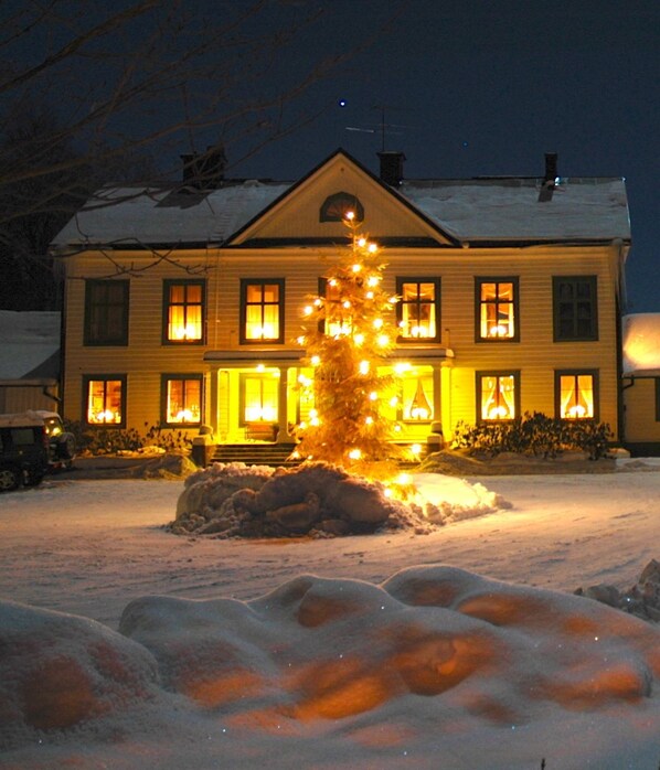 Vista frontal de la propiedad por la tarde o noche