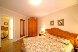 Une chambre à coucher avec un lit en bois, une table de chevet avec une lampe et une armoire.