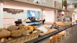 A buffet counter with various breads and pastries. - Hotel Am Freischuetz (Huerth)