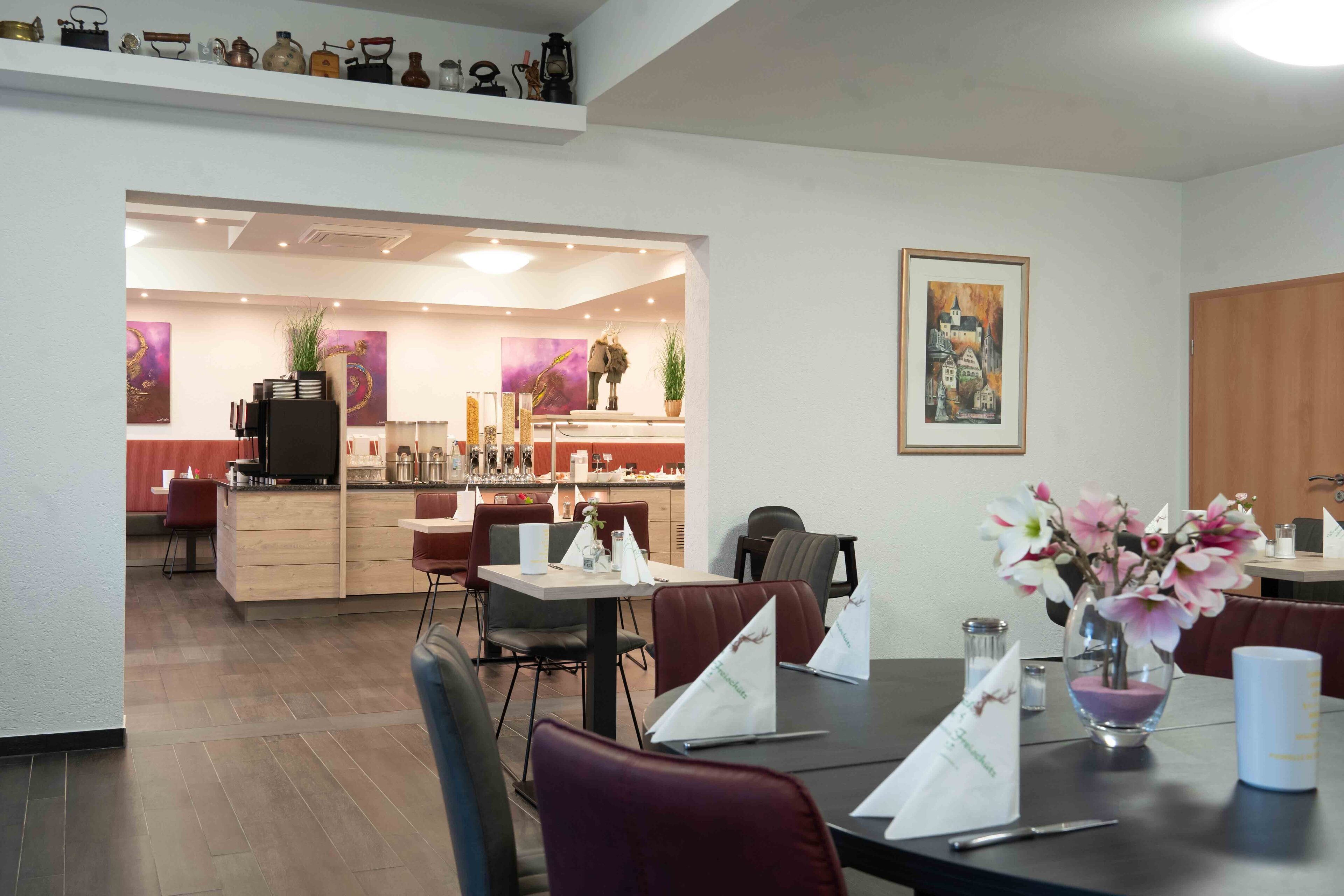 Un espace repas moderne avec un îlot central, des chaises rouges et un vase de fleurs.
