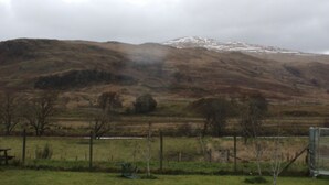 A rural landscape with a fence, a bench, and a hill with snow. - The Luib Hotel (Crianlarich)