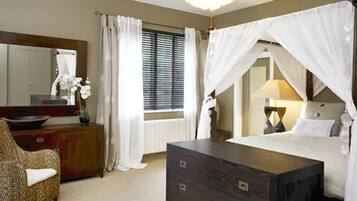 Un dormitorio con cama, cómoda, silla, espejo y ventana con cortinas.