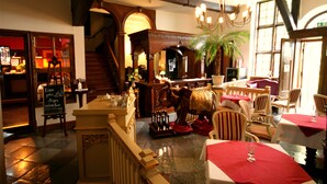 A restaurant with a bar area, wooden furniture, and a staircase. - Hotel Denkmal 13 – Rostock (Rostock)