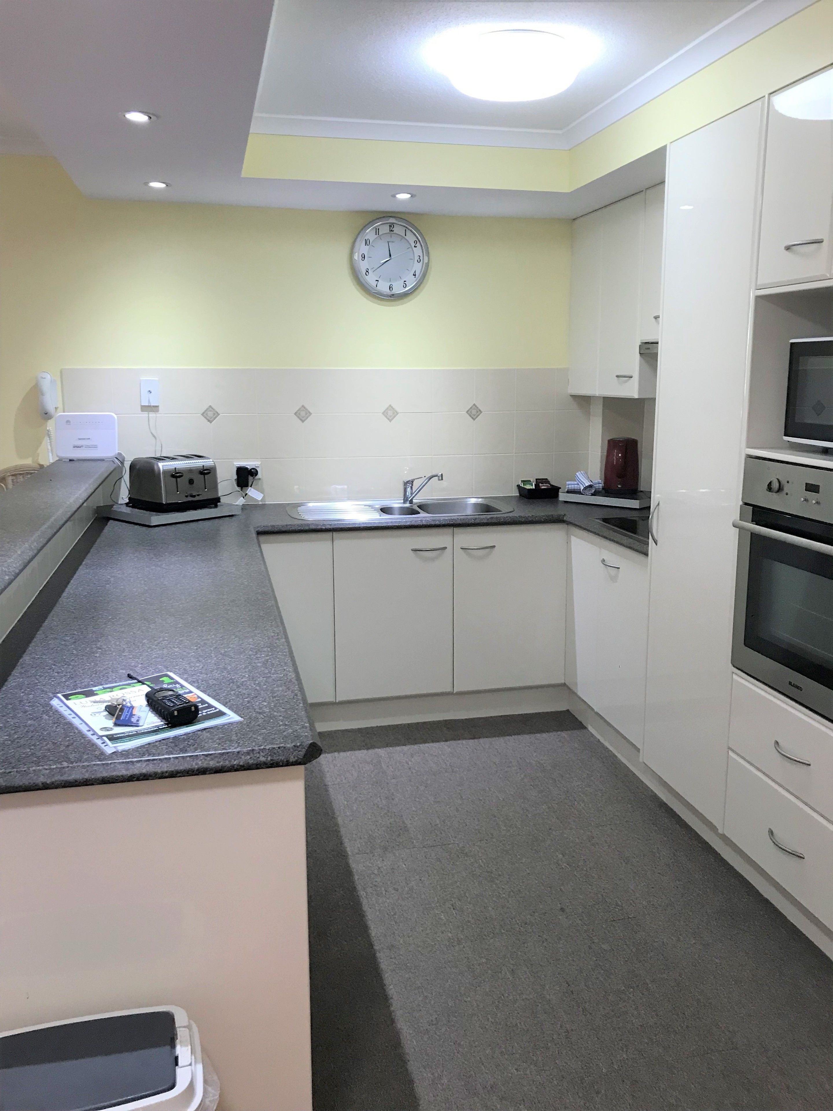 A compact kitchen with a sink, toaster, microwave, and oven.