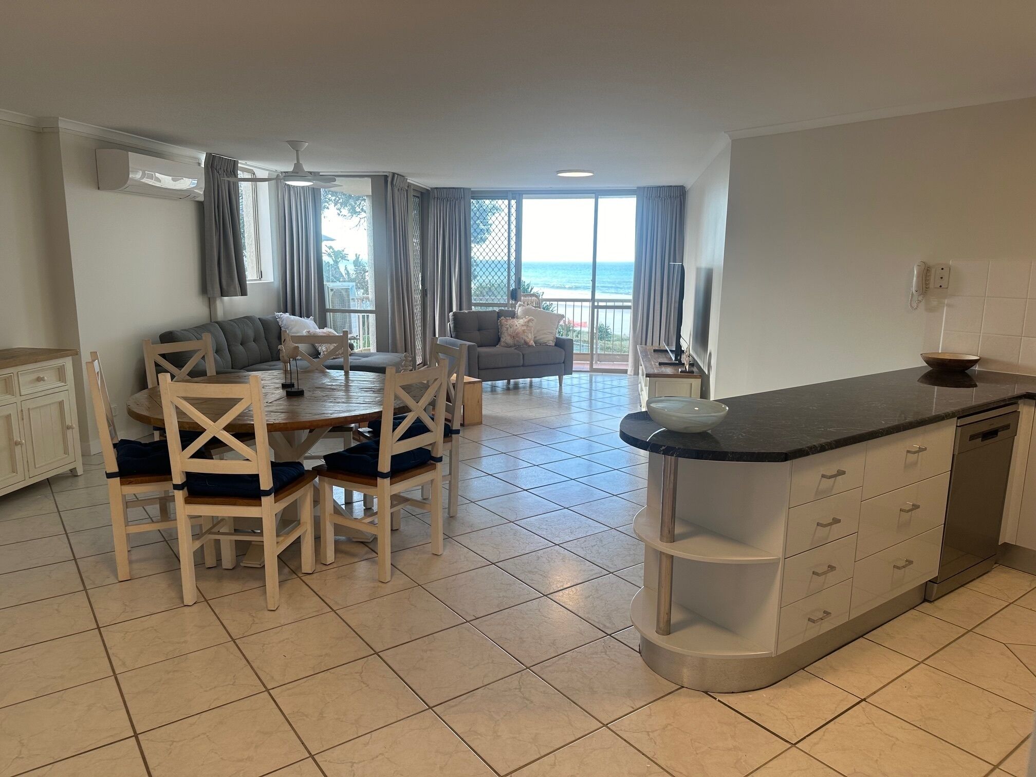 Una cocina moderna con comedor, un sofá y vista al mar.