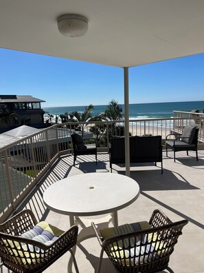 A covered outdoor seating area with a view of the beach and ocean. - Sanctuary Beach Resort (Currumbin)