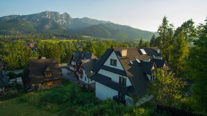 Un barrio residencial con casas de techos inclinados y montañas al fondo.