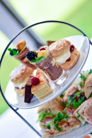 A multi-tiered dessert display with various pastries and a glass of chocolate mousse. - Astley Bank Hotel (Darwen)