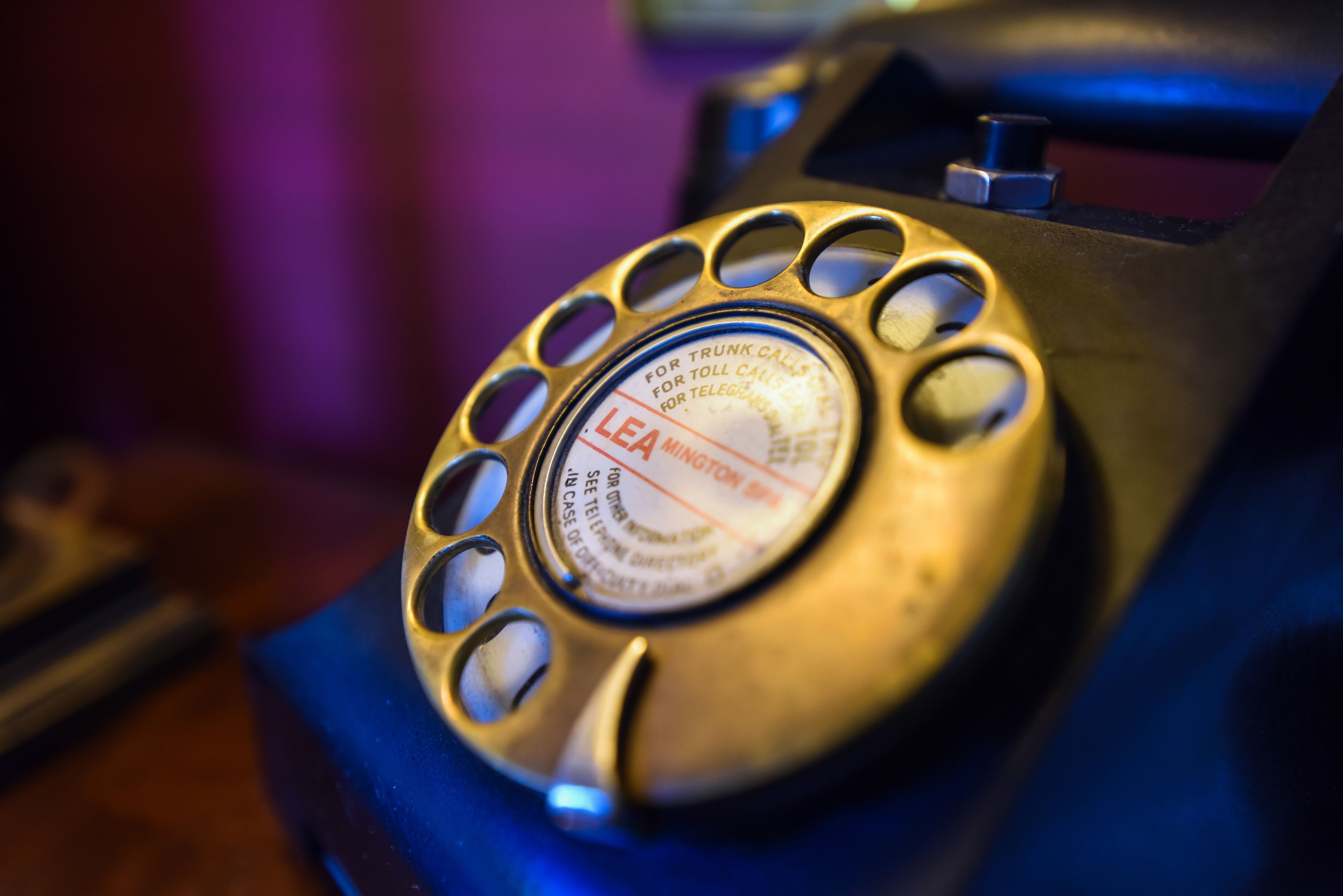 A close-up of a rotary dial telephone with a circular design and holes around the dial.