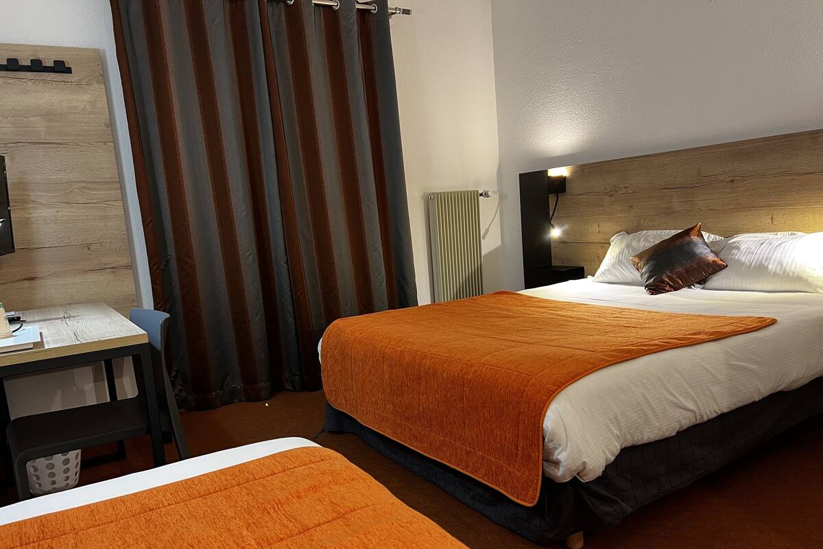 Een hotelkamer met een bed, een bureau en een stoel.