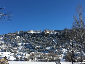 A snow-covered landscape with buildings on a hill. - Hotel Lacour (Eygliers)