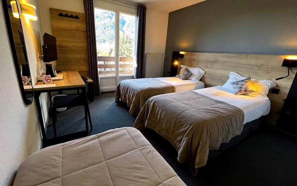 Una habitación de hotel con dos camas, un escritorio y una silla.