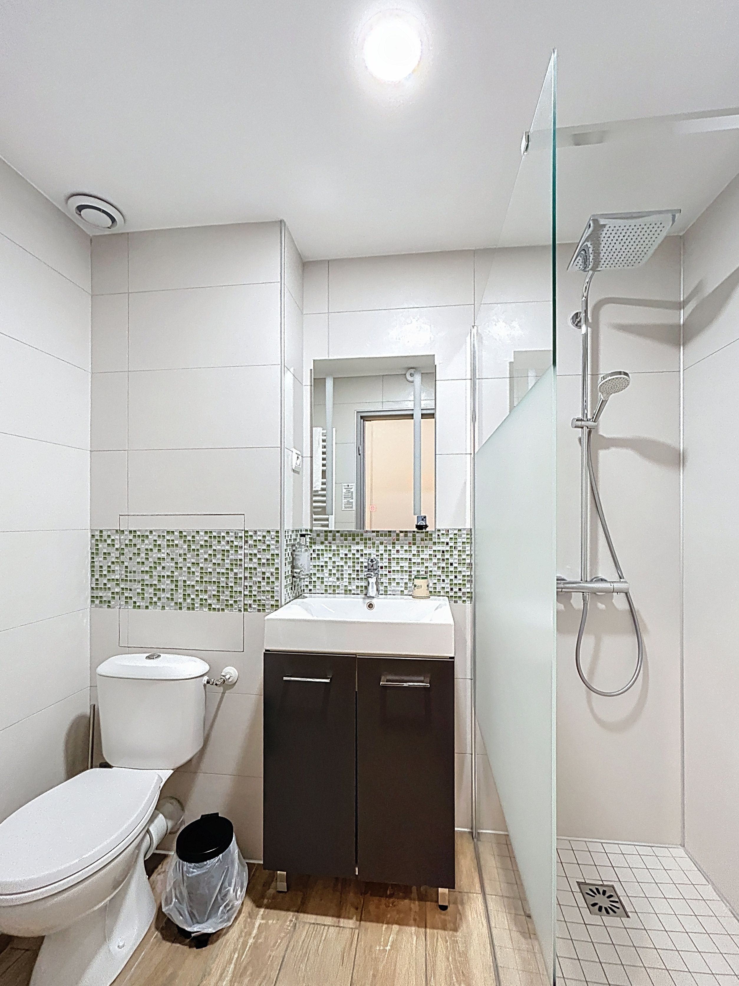 A bathroom with a toilet, sink, and shower.