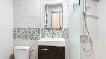 A bathroom with a toilet, sink, and shower.