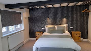Relax in a serene bedroom with a large bed, two nightstands, and a wavy-patterned wallpaper.