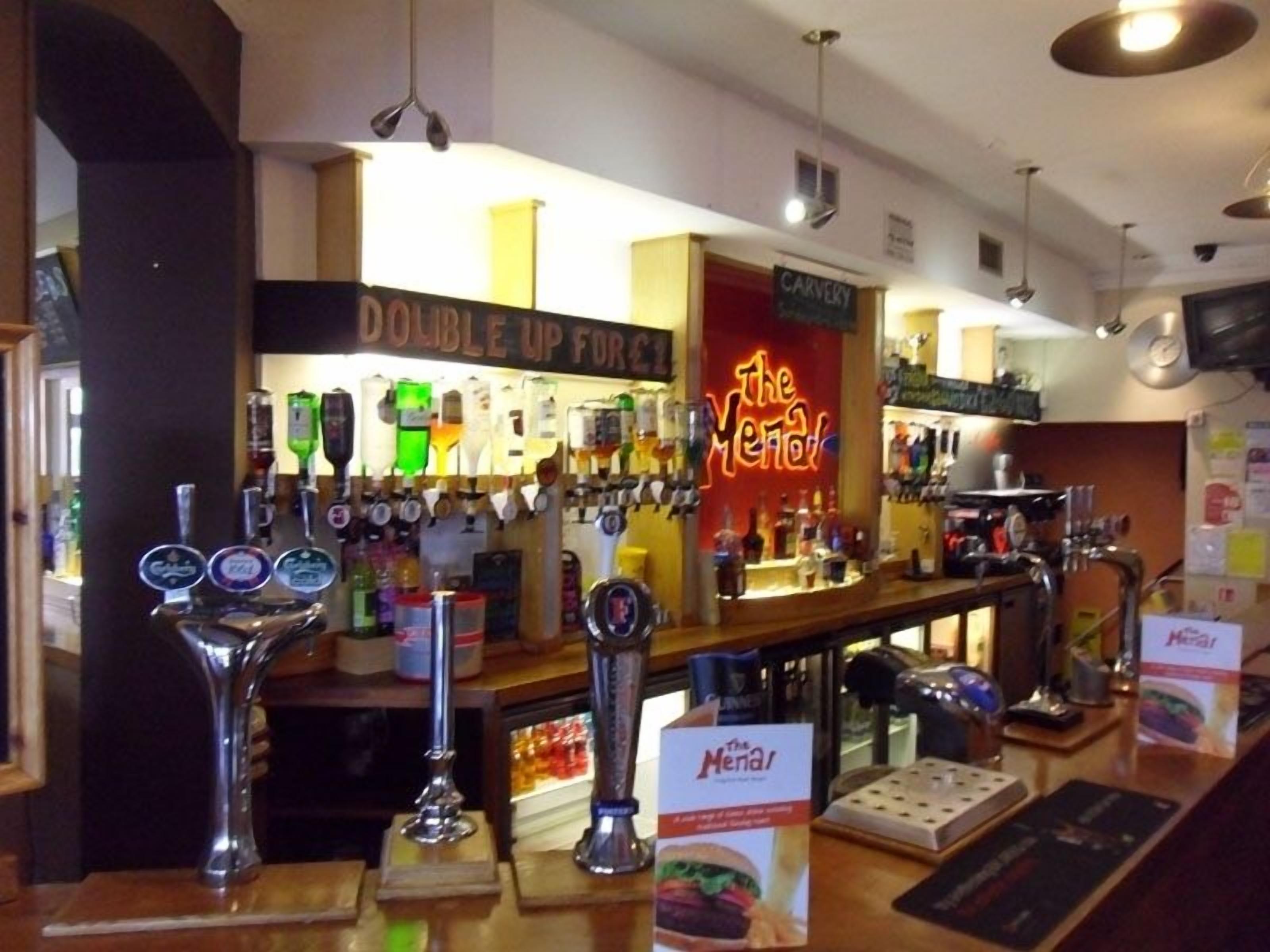 A bar area with multiple beer taps and a neon sign reading "The Yeti".